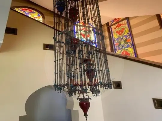 Villa for sale in Sheikh Zayed interior staircase with luxurious chandelier