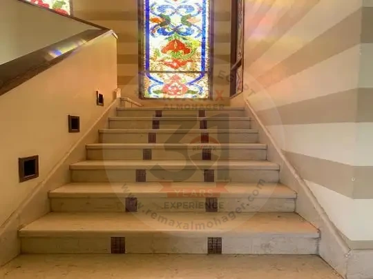 Villa for sale in Sheikh Zayed spacious interior staircase with elegant finishing and stained glass window